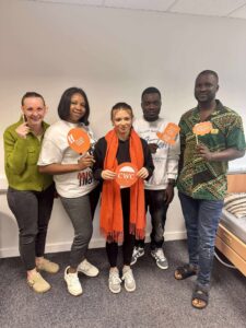 Five of our new starters at training holding props for Wear It Orange Day to support the CWC.